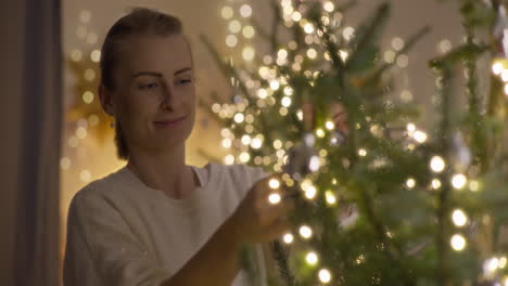 mujer decorando arbol de navidad