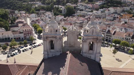 aerial pan shot of cistercian monastery of alcobaca overlooking at front foyer and housing townscape