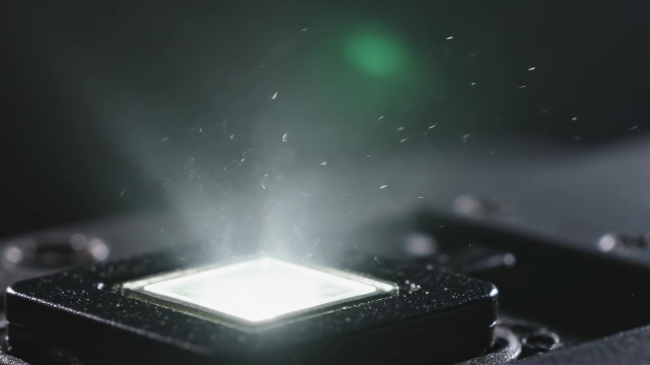 Powering module causing square LED die brightening on test bench, revealing dust plume, screws
