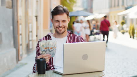 happy rich man counting money dollar cash menu app ordering food delivery online in city cafeteria