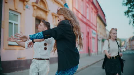 jóvenes bailando alegremente en una calle de la ciudad
