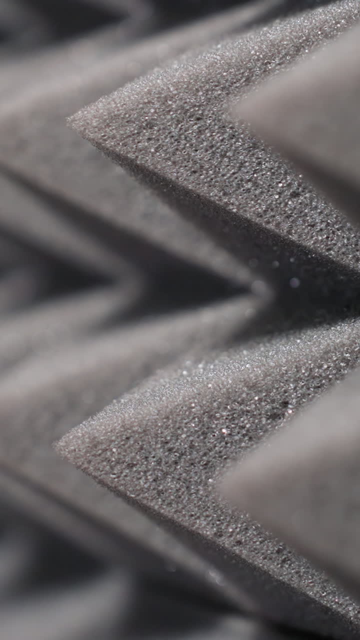 vista de cerca de paneles de espuma acústica en forma de pirámide diseñados para la absorción de sonido. ideal para la configuración de estudio o audio, mostrando textura detallada y aislamiento acústico eficaz