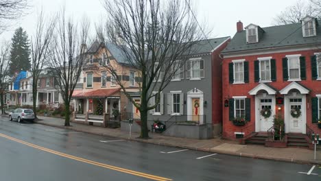 establishing shot of victorian homes along street in american town