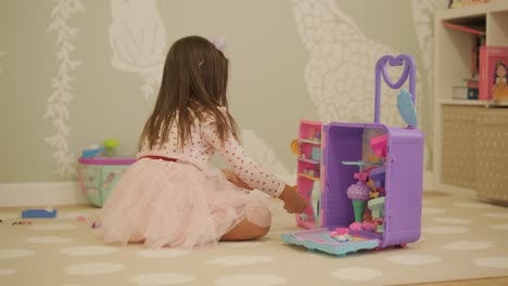 little girl playing in playroom in pretty dress