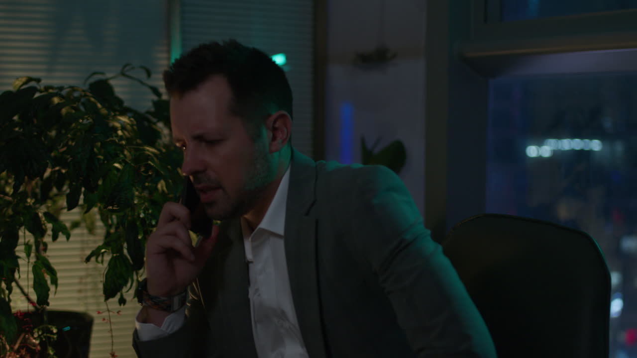 Businessman on Phone at Night in Office