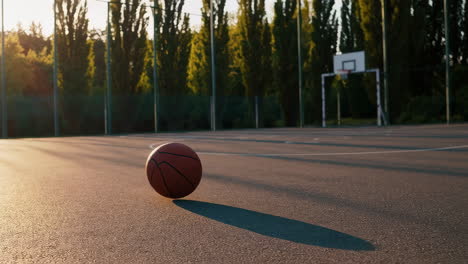 basketball on an outdoor court at sunset