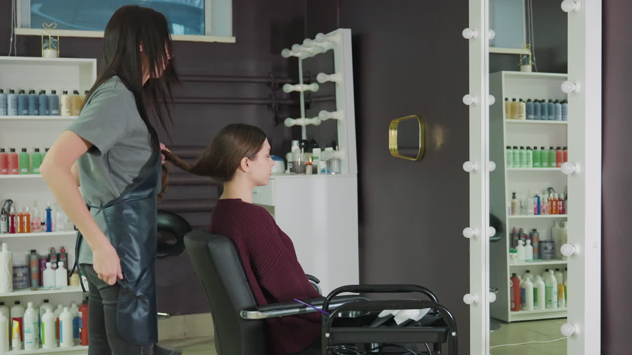 parrucchiere che prepara i capelli, esperto di bellezza che divide i capelli lunghi prima di acconciarli o trattarli, stilista di origine europea che prepara i lunghi ciuffi di prova prima del processo di taglio o acconciatura
