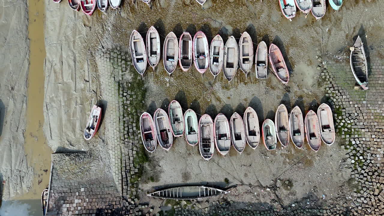 Cinematic overhead drone shot of many boats left in the ship graveyard in Bangladesh. downward angle