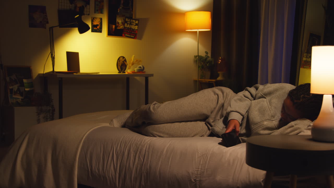 밤 에 전화 를 사용 하는 침대 에 있는 여자