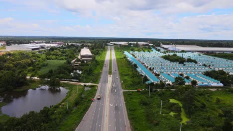 Descending-aerial-drone-clip-over-a-highway-with-cars-passing-by-in-northern-Thailand