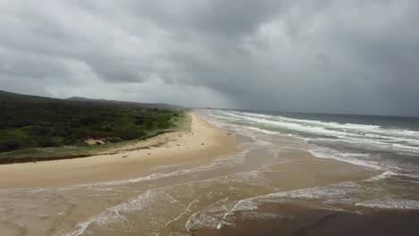 Vista-Aérea-De-Una-Larga-Playa-Vacía-En-Australia-Con-Nubes-De-Tormenta-En-El-Fondo