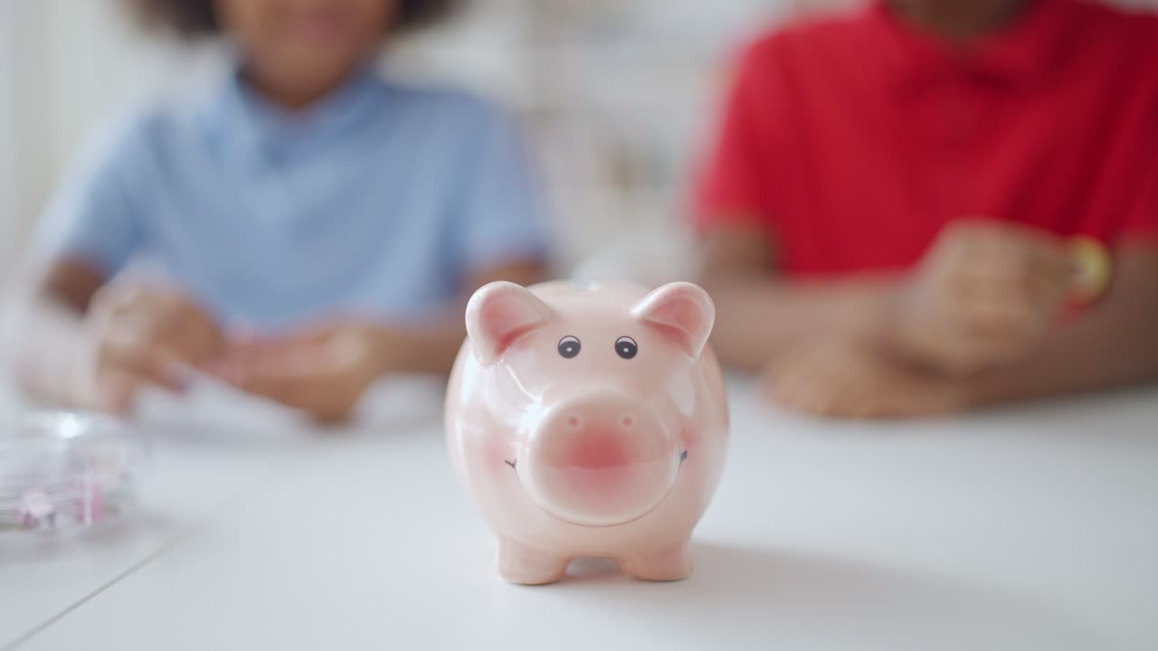 Children putting money into piggybank, saving for something special, dream
