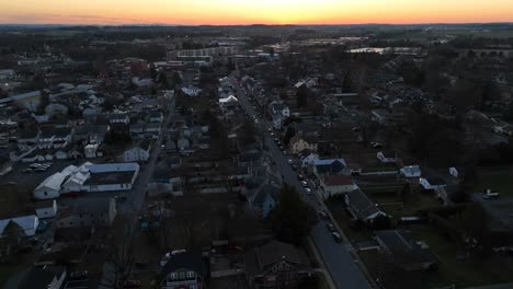 aerial orbit shot around american town at sunset time