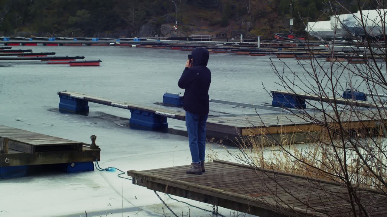 Person taking pictures of a frozen lake in Eidanger, Norway