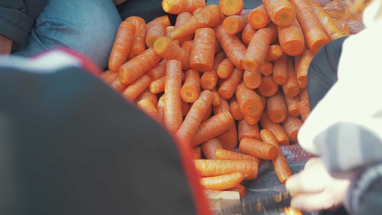 refugiados afganos cortando y preparando zanahorias en un campo de refugiados