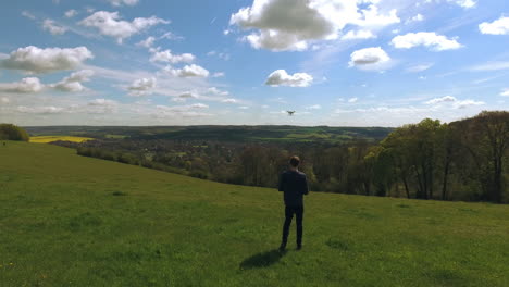 Toma-Aérea-De-Un-Hombre-Volando-Un-Dron-Sobre-El-Campo