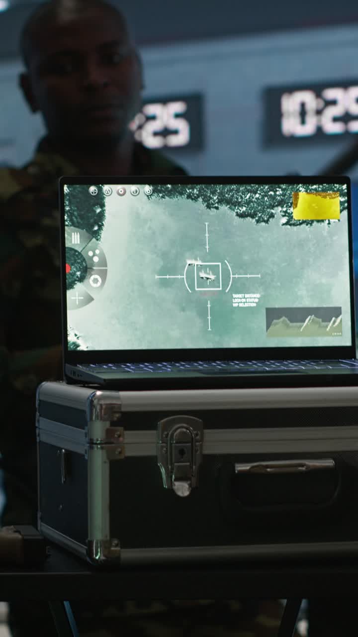 Video verticale: Esperto dell'esercito che esamina i dati in una sala di monitoraggio con un laptop.