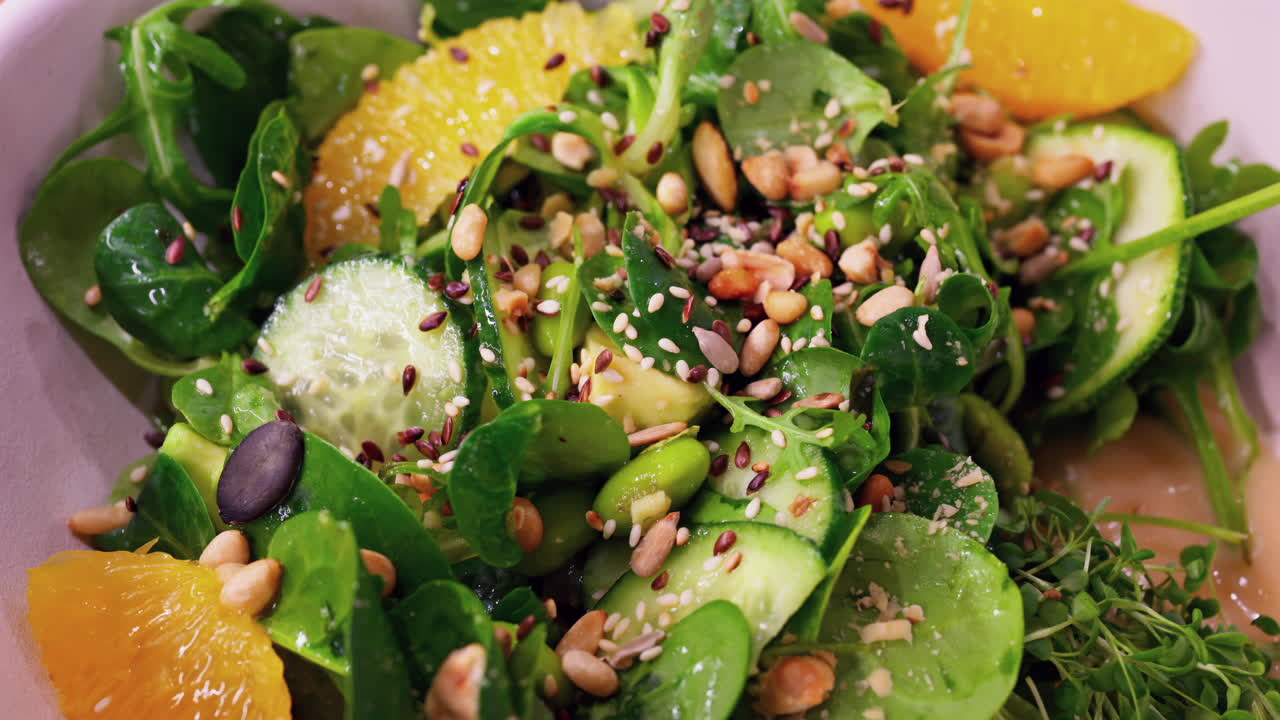 Close up of a green salad with seeds and oranges