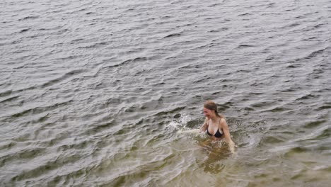 Caucasian-couple-having-a-good-time-on-a-trip-to-the-mountains,-wearing-bathing-suits-and-swimming-i