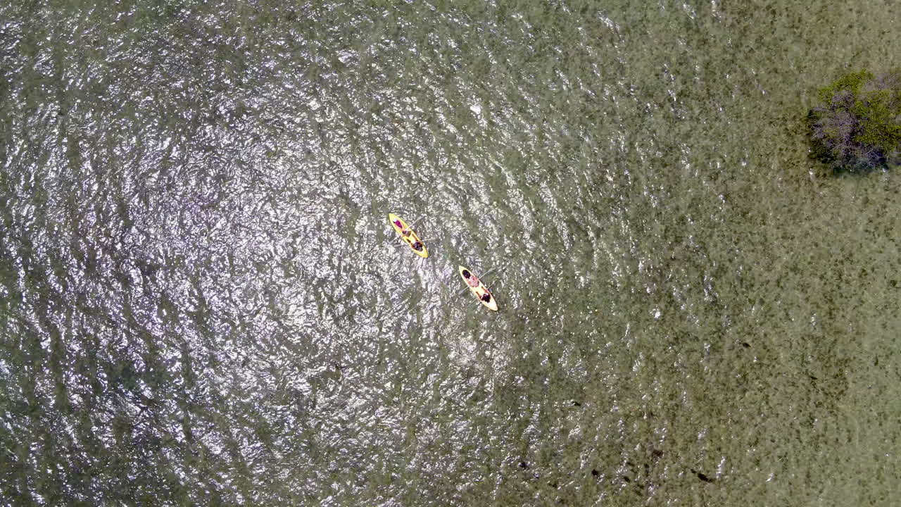 여름에 인도네시아 서부 발리의 맑은 석호 표면에서 노를 젓는 카약