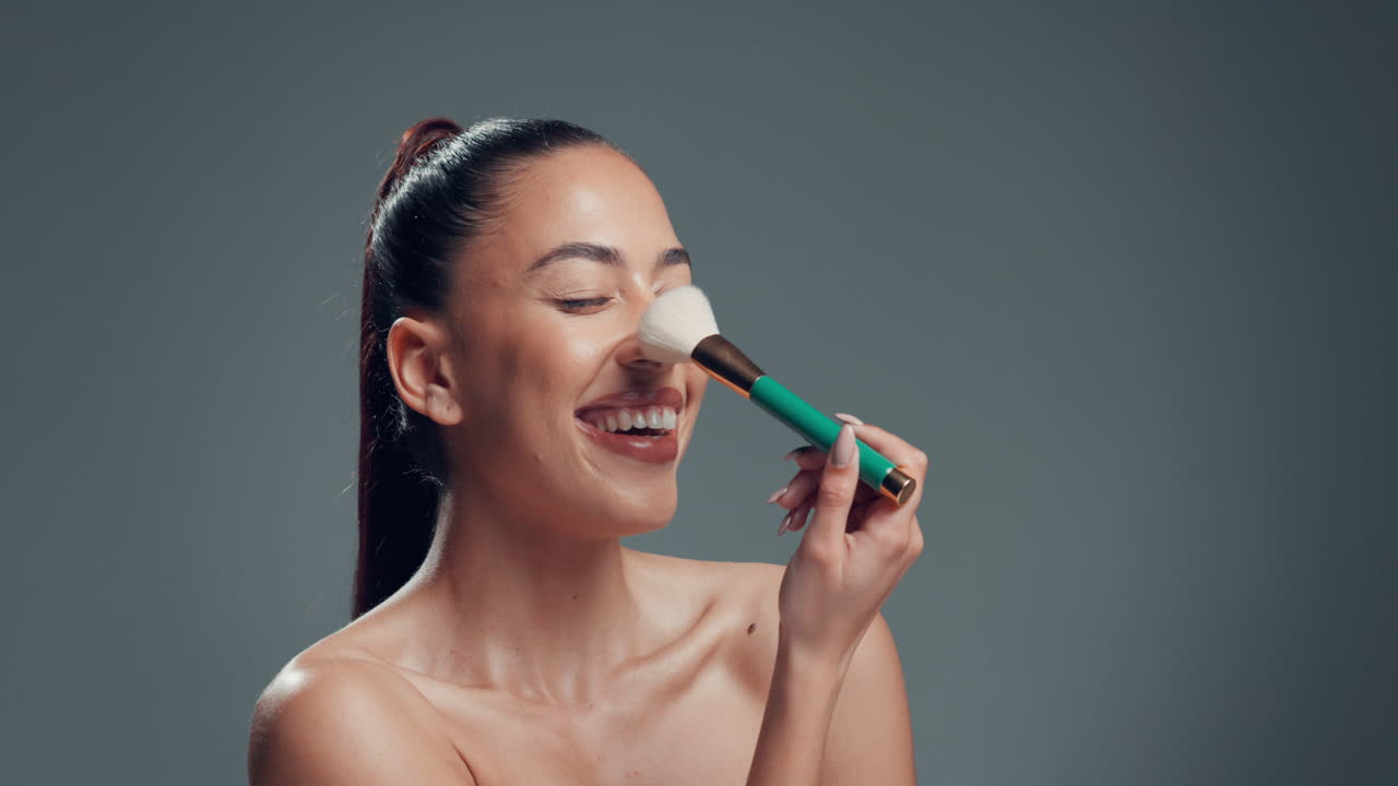Beautiful woman applying makeup with a brush