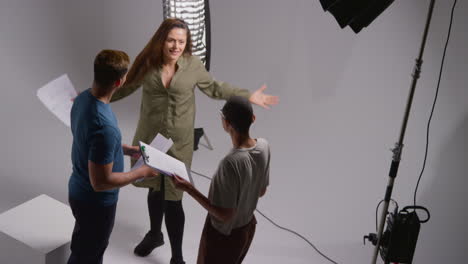 fotografía aérea del director de cine hablando con actores masculinos y femeninos sosteniendo guiones ensayando para filmar una película o video en el estudio 1