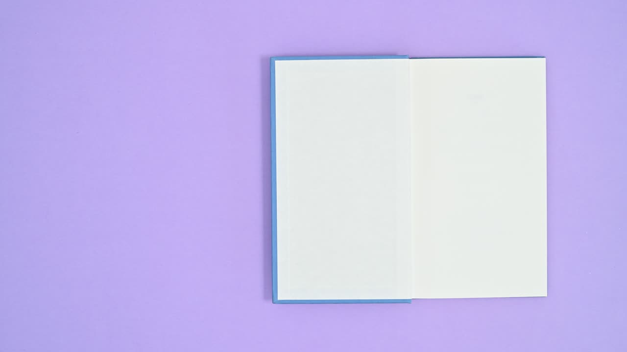 Blue hardcover retro book come on purple theme and open. Stop motion flat lay
