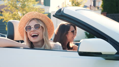 two happy women enjoying a convertible ride