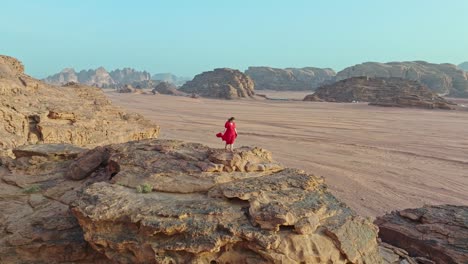 Rising-On-A-Woman-Standing-Over-Natural-Sandstone-Cliffs-In-Wadi-Rum-Protected-Area,-Jordan