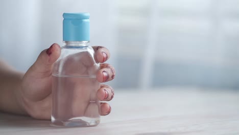 hand holding hand sanitizer bottle