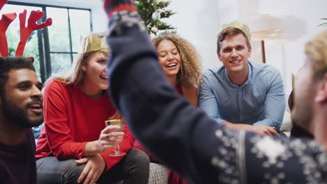 group of friends playing charades after enjoying christmas dinner at home