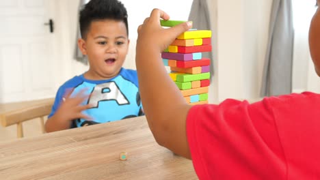 two brother play wood block tower game
