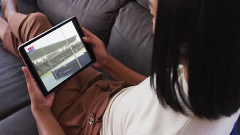 composite of woman sitting at home on couch watching athletics high jump event on tablet