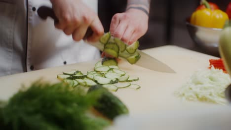 el chef cortando pepinos