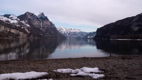 Close-slide-shot-over-a-sand-beach-in-the-winter-in-Weesen,-Switzerland