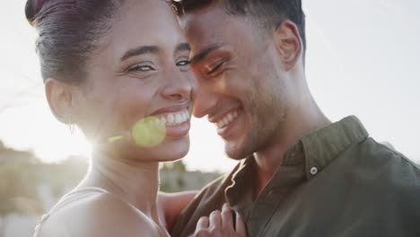 backlit diverse bride and groom laughing and smiling at beach wedding, in slow motion