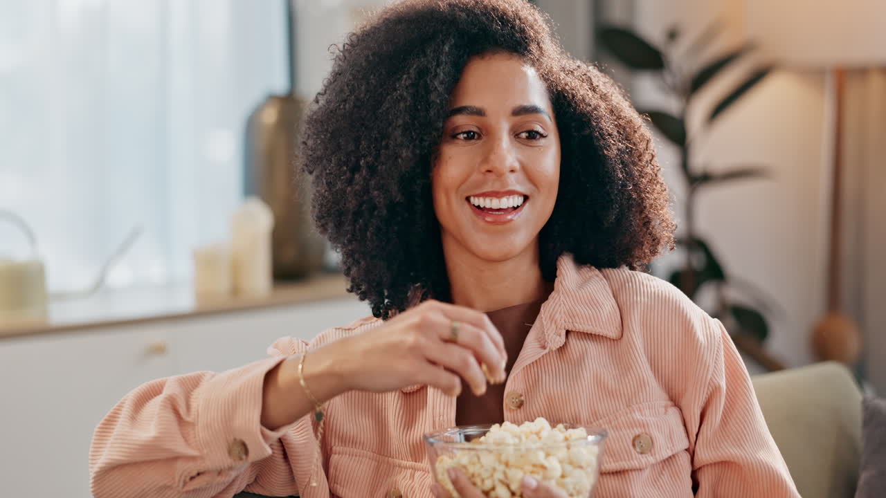 Donna con capelli ricci che mangia popcorn