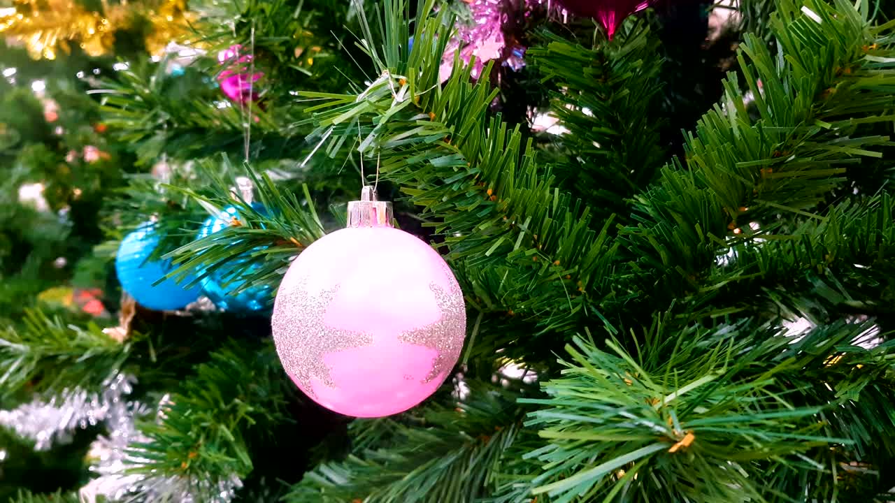 adornos coloridos decoran en un árbol de navidad. saludo de la temporada de video de fondo