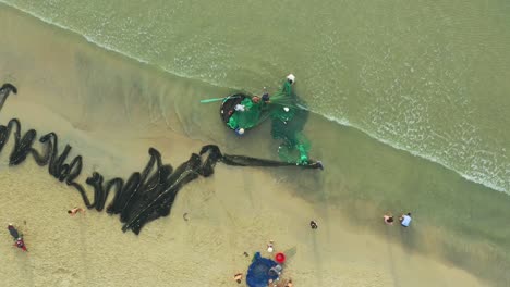 Drohnenansicht-Fischer-Ziehen-Fischernetze-Zum-Korbboot-An-Meinem-Khe-Strand-Bei-Der-Stadt-Da-Nang