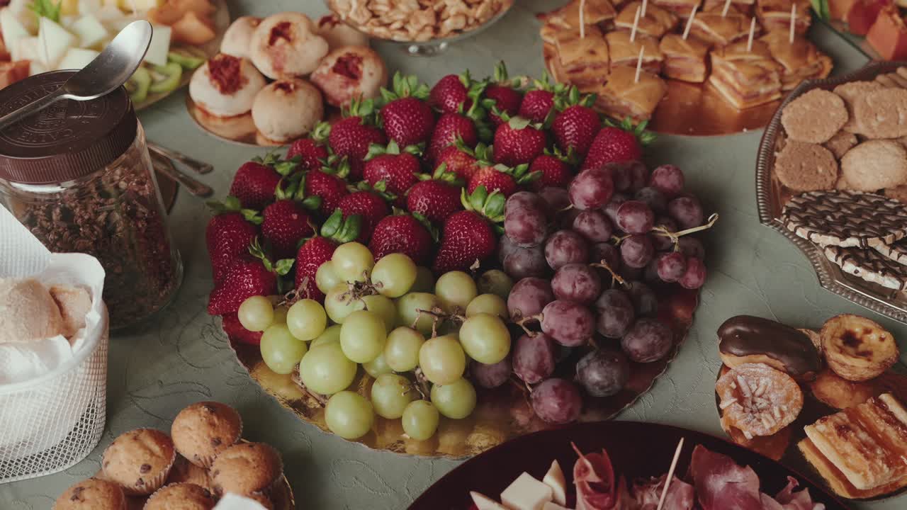 mixed fruit and pastry buffet table with assorted snacks and desserts