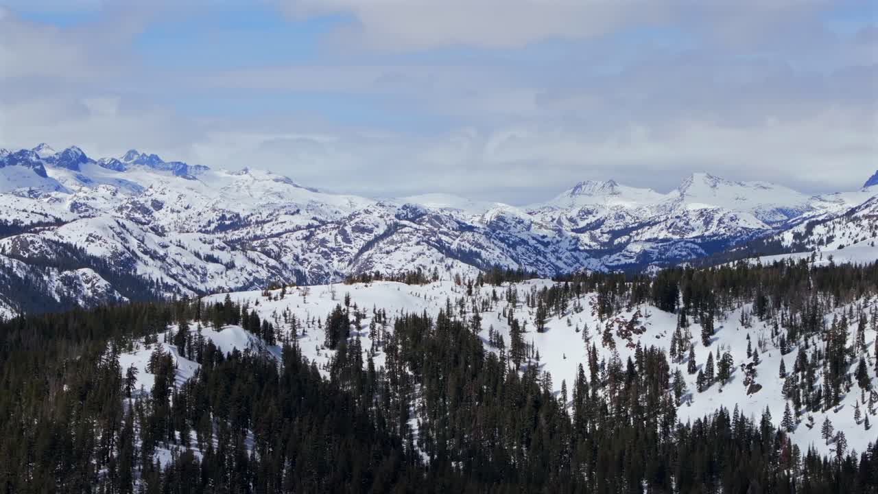 Minarets mountain range jagged towering peaks vista point Mammoth Mountain ski resort aerial drone California winter spring sunny blue sky morning Inyo National Forest panoramic landscape pan left