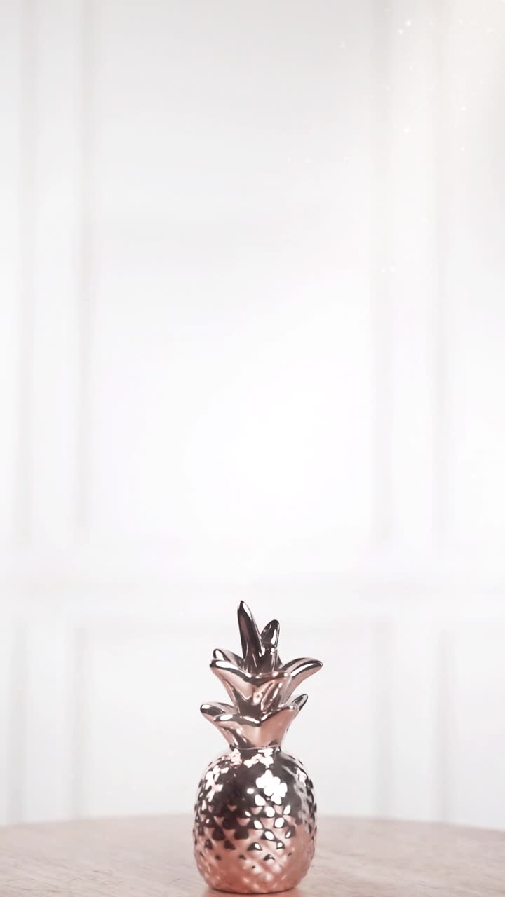 Decorazione ananas color oro rosa lucido con particelle scintillanti su sfondo bianco