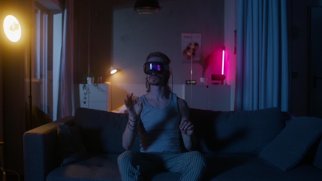 Uomo che usa un visore VR su un divano di notte