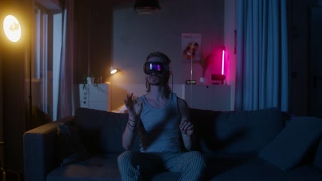 man using vr headset on a couch at night