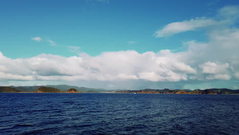 beautiful scenery of island by the rippling ocean under blue sky with cloudscape - bay of islands in new zealand