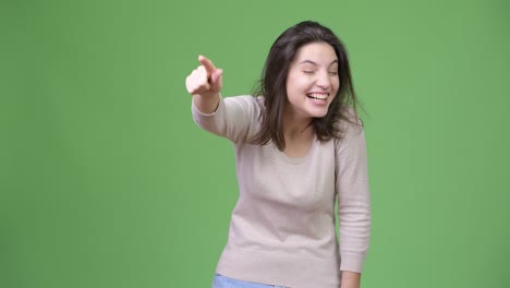 young happy beautiful woman laughing while pointing finger