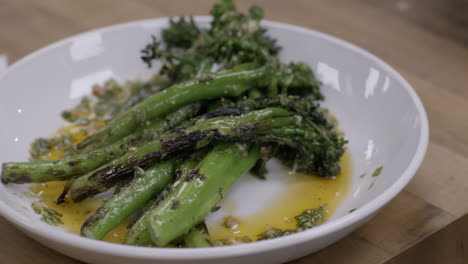 broccoli rob is plated in the kitchen of an upscale restaurant then silverware is placed beside it