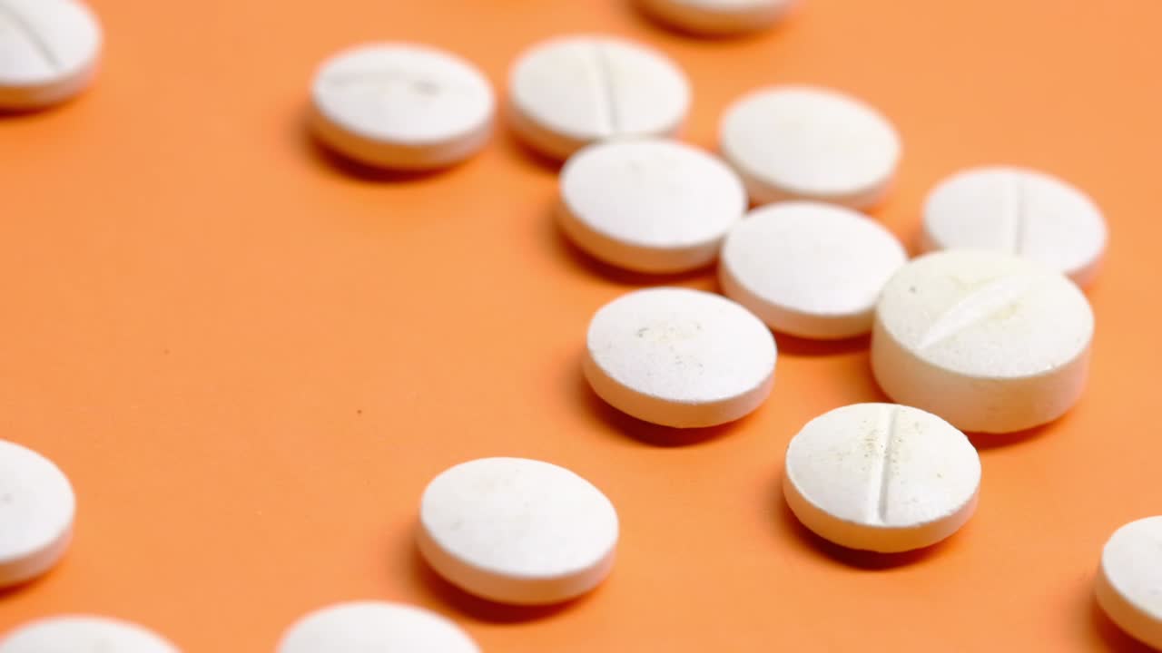 pastillas blancas sobre un fondo naranja