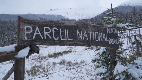 Rustic-wooden-sign-at-entrance-of-Mount-Rodnei-National-Park-in-Northern-Romania,-a-popular-mountain-climbing-destination