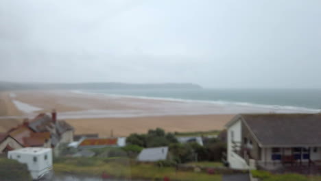 Abstract-Shot-of-Rain-Flowing-Down-a-Window-with-a-Beach-View-in-Soft-Focus